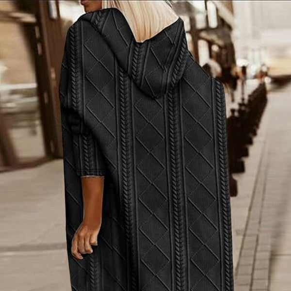 Person wearing a black cable knit cardigan on a city street.